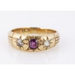 A 18c marked yellow metal three stone ruby and diamond dress ring, an oval mixed cut ruby