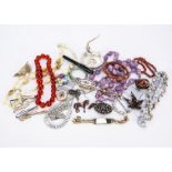 A quantity of costume jewels, including beads, bangles, brooches and other items (a parcel)