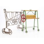 A Tri-ang toy mangle, painted green -- 20in. (48cm.) high and a cast-iron rocking cradle