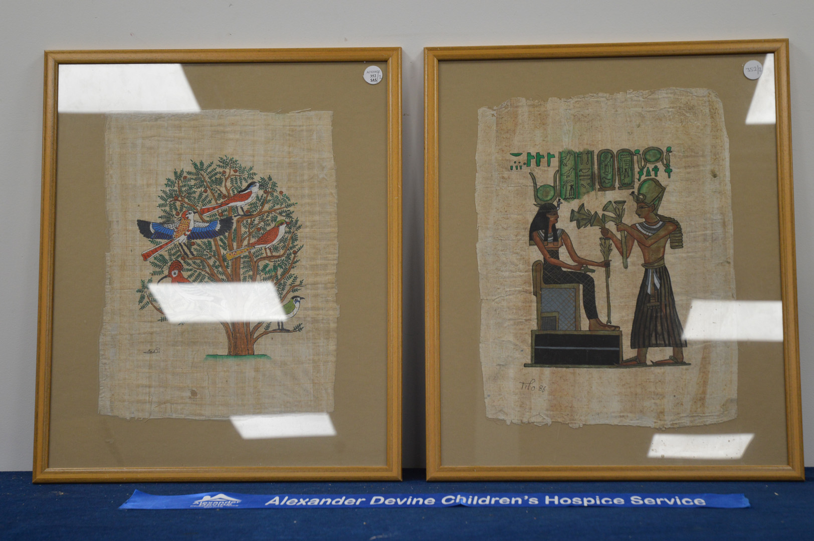 A pair of 20th century framed papyrus works of art, depicting classical Egyptian scenes, both 59cm x