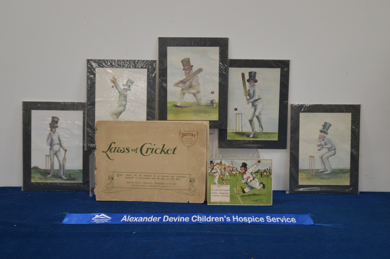 Five mounted cricket prints, together Perrier 'Laws of Cricket' caricature album, the album 27cm x