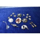 An oval porcelain and silver framed brooch, a set of eight paste buttons, A Mircale brooch, and