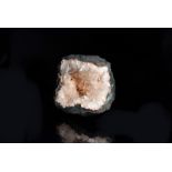 A Zeolite and Stilbite geode, with clear and pale pink mineral formation in the centre, discovered