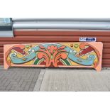 A vintage Fairground ride panel, with vibrant colours with scroll design to background