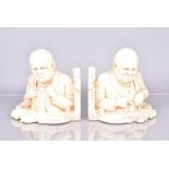 A pair of plaster bookends by Jon Douglas, dated 1955, one of Churchill re-arranging his jacket, the
