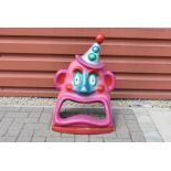 A vintage Fairground fibreglass clown ball throwing game topper, with purple/pink head, 69cm H