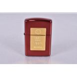 A 2021 Red Ingot Zippo lighter, with red metallic case, with yellow metal ingot design to the centre