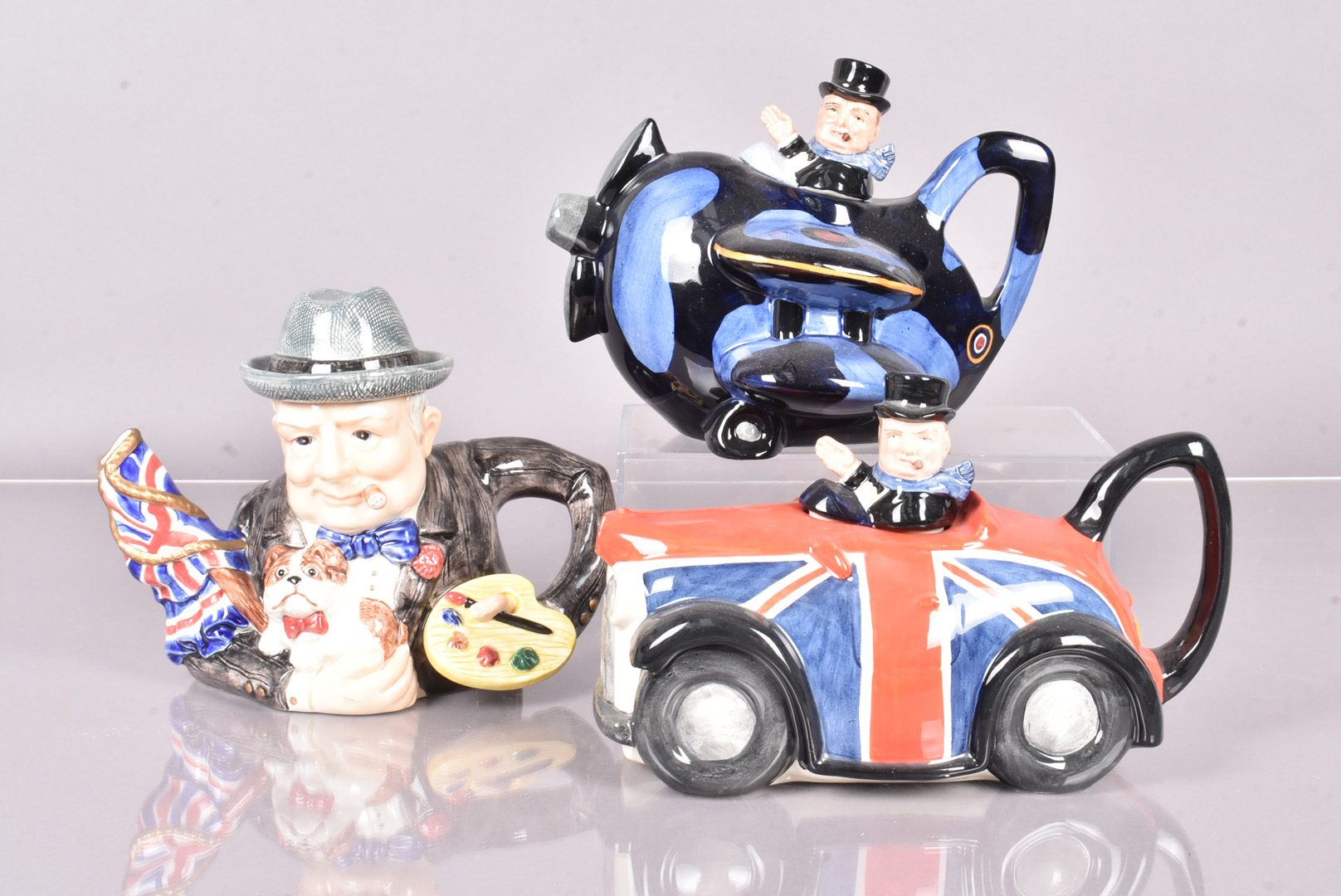 Two Carlton Ware Winston Churchill teapots, one in the form of a car with Union Jack decoration, the