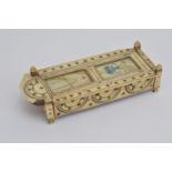 A Napoleonic prisoner of war bone games box, with a sliding lid, the lid with two glazed panels (one