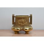 An early to mid 20th century Chinese brass censer, pierced twin handles raised dragon and mythical