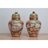 A pair of late 19th century Japanese ceramic baluster vases with covers, both with red and gilt