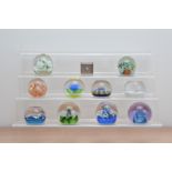 A collection of paperweights, of varying designs and styles, including seven Caithness examples,
