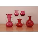 A collection of cranberry glassware, comprising a twin handled vase 19cm high, with a shorter