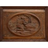 An early 20th century Black Forest carved wooden panel, depicting a hunter with a spear hunting a