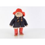 A Gabrielle Design Paddington, in blue duffel coat with red hat and red Dunlop Wellington boots —