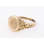 An Edwardian yellow metal signet ring, oval tablet with engraved initials, with scroll design to