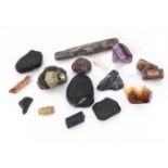 A small collection of rough/natural gemstone crystal forms, including a Topaz, jet, smoky quartz,