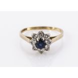 An 18ct gold sapphire and diamond cluster ring, the circular mixed cut sapphire in claw setting