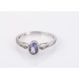 A 9ct white gold three stone tanzanite and diamond three stone ring, oval mixed cut, ring size N,