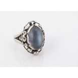 A George Jensen silver and moonstone dress ring, oval cabochon, in a scroll bead setting, (af),
