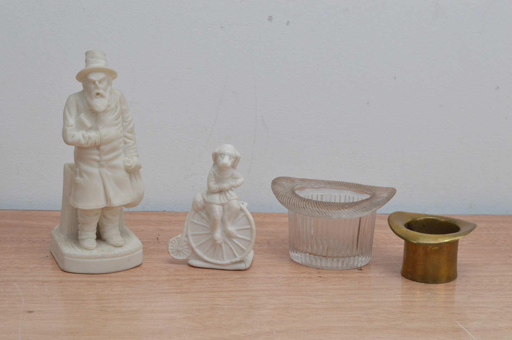 Four novelty table match strikers, two in the form of top hats, one brass and one glass 4cm & 5.