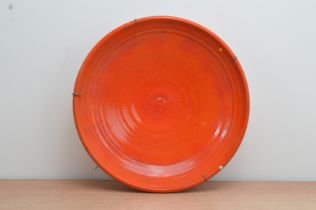 A 20th century Italian stoneware charger, vermillion mottled glaze with a ribbed center, with wall