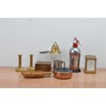 A collection of works of art, including a brass carriage clock, brass candlesticks, a brass bell and