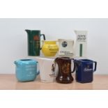 A collection of eight ceramic branded water jugs, comprising two Dewar's, Bowmore, Inverhouse,