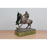 An art deco style early 20th century white metal medieval man on horseback, holding a green glass