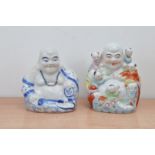 Two 20th century Chinese ceramic buddha's, one blue and white, the other coloured with climbing