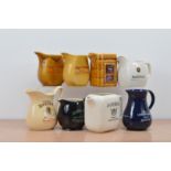 A collection of eight ceramic branded water jugs, comprising two King of Kings, Logan, The Real