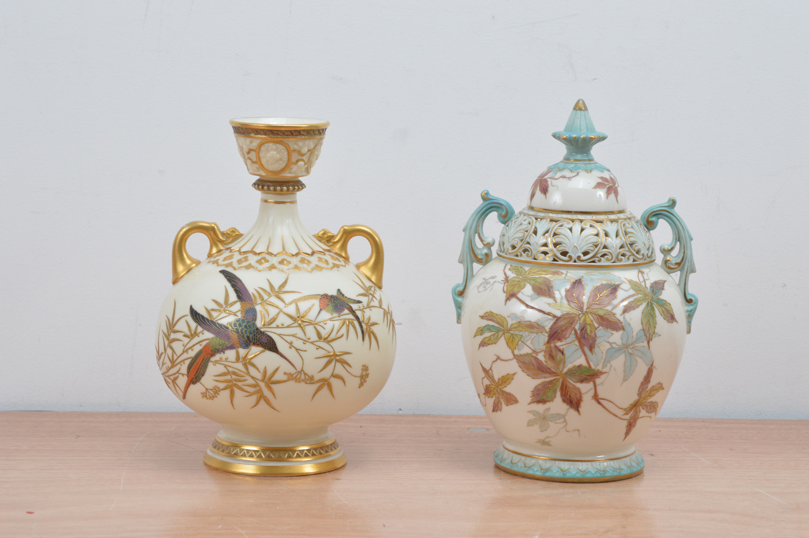 A Royal Worcester ceramic cream and gilt twin handled vase, with flying bird decoration, marked to