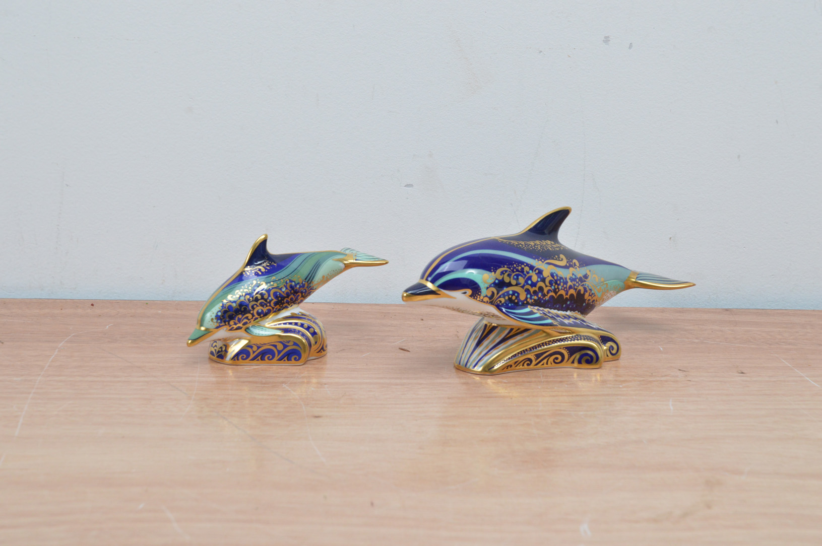 Two Royal Crown Derby bone china paperweights, both dolphins, Lyme Bay Dolphin and baby Lyme Bay