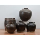 Five 20th century Oriental stoneware slipware vessels, brown slip, of various sizes and condition,
