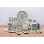 A large collection of modern Wedgwood Jasperware items, all in green, including vases, plates,