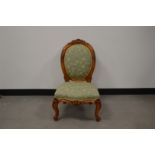 A Victorian walnut upholstered balloon back nursing chair, finely carved back, serpentine fronted