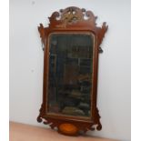 An early 20th century mahogany fretwork mirror, mounted with a gilt painted bird, surmounted with
