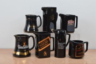 A collection of seven ceramic Whiskey branded water jugs, comprising two Glenfiddich, two Johnnie
