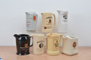 A collection of seven ceramic Whiskey branded water jugs, comprising Queen Anne, Bowmore, Jameson,