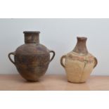 Two twin handled tribal/Islamic terracotta oil jars, of differing sizes and styles, the largest with