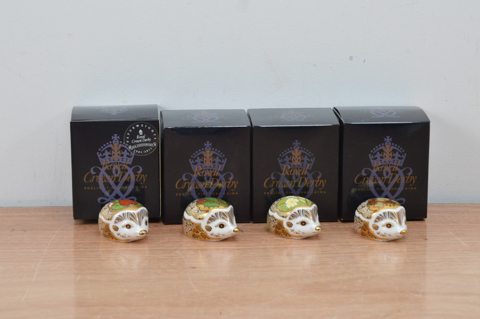 Four Royal Crown Derby bone china paperweights, all hedgehogs, Strawberry, Primrose, Holly and