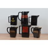Four Dunhill ceramic water jugs, together with two John Player Special jugs, all black with gilt
