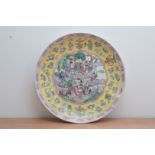 An early 20th century Chinese ceramic famille rose palette charger, central panel depicting a