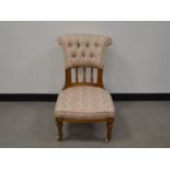 An Victorian low walnut upholstered chair, button upholstered back above finely turned and marquetry