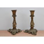 A pair of 19th century brass candlesticks, rococo design, raised on three feet, some wear, 22cm high