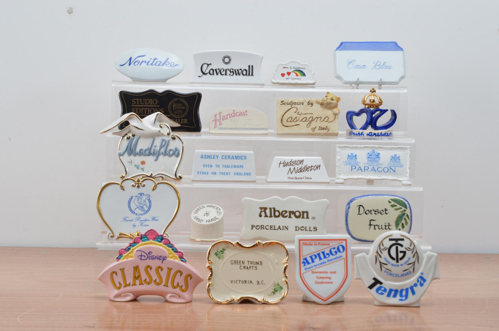 An assorted collection of ceramic advertising plaques, including Disney, Paragon, Caverswall,