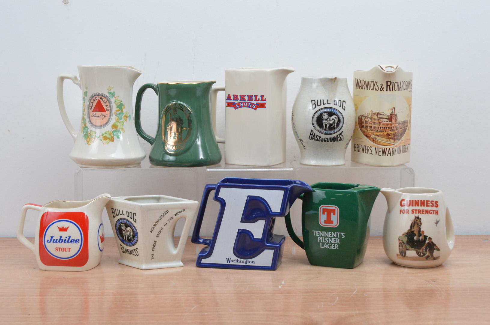 A collection of ten ceramic beer branded water jugs, including Jubilee Stout, Tennents, Guinness,