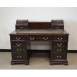 An Edwardian mahogany twin pedestal desk, brass gallery, fretwork to drawer fronts, the top with