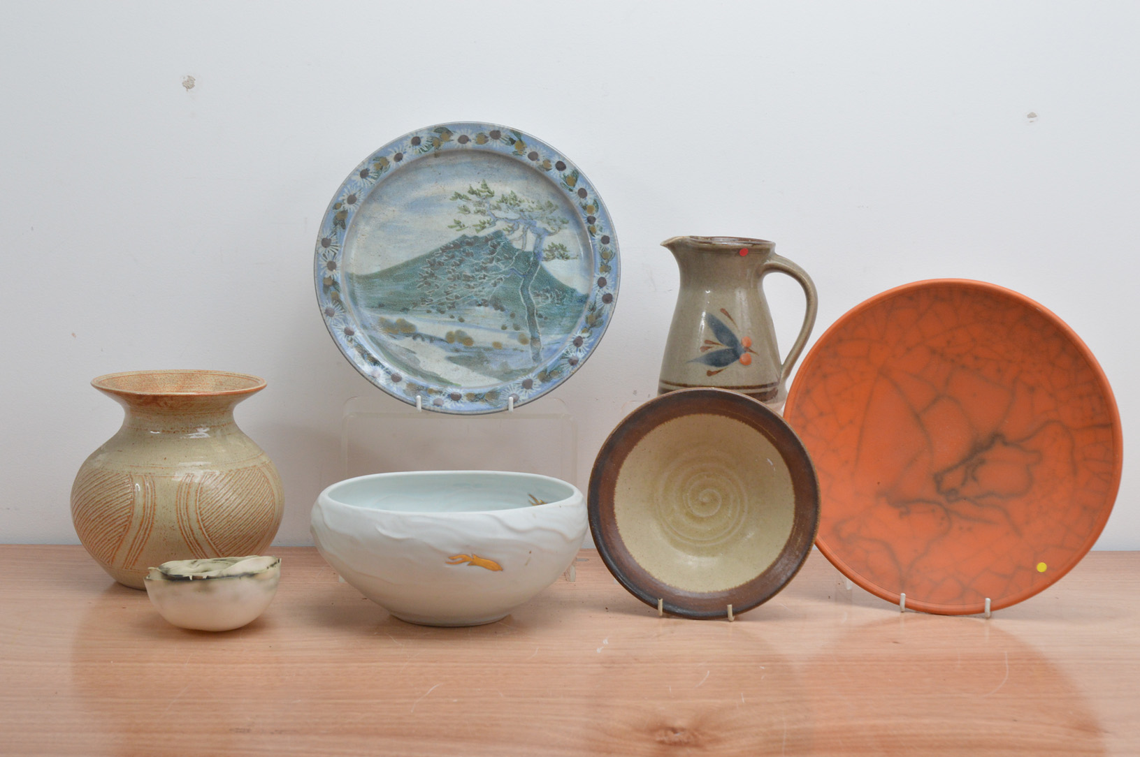 A collection of 20th century studio pottery, comprising a raku red glazed shallow bowl by Jo