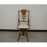 An Edwardian mahogany and boxwood inlaid swivel chair, Sheraton style marquetry carved back, bow
